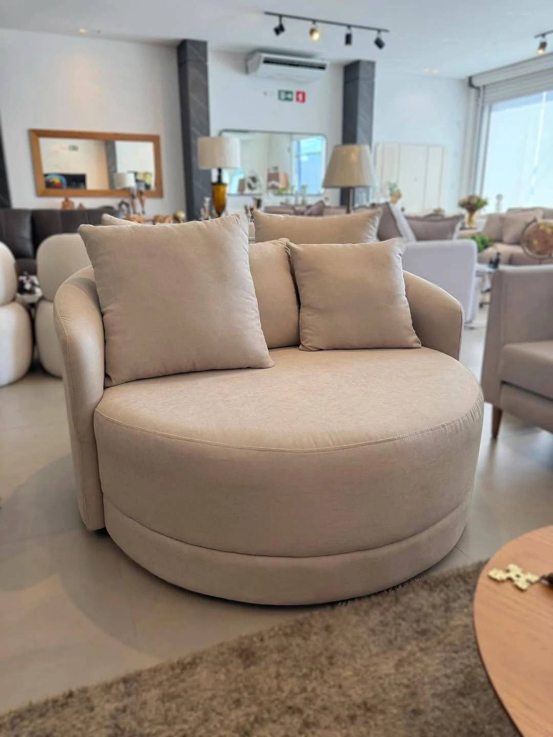 Poltrona arredondada em tom claro no showroom Innovare Home